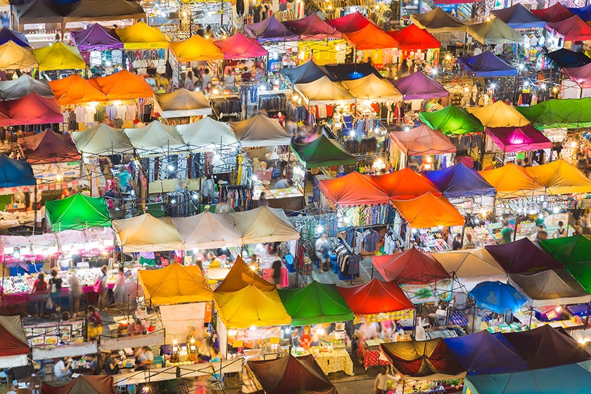 An aerial view of tents and stands at a night time flea market
