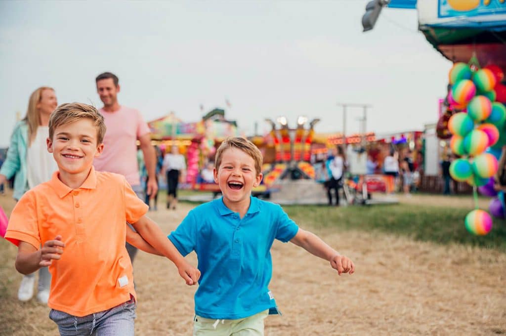 Children running and laughing at a state fair