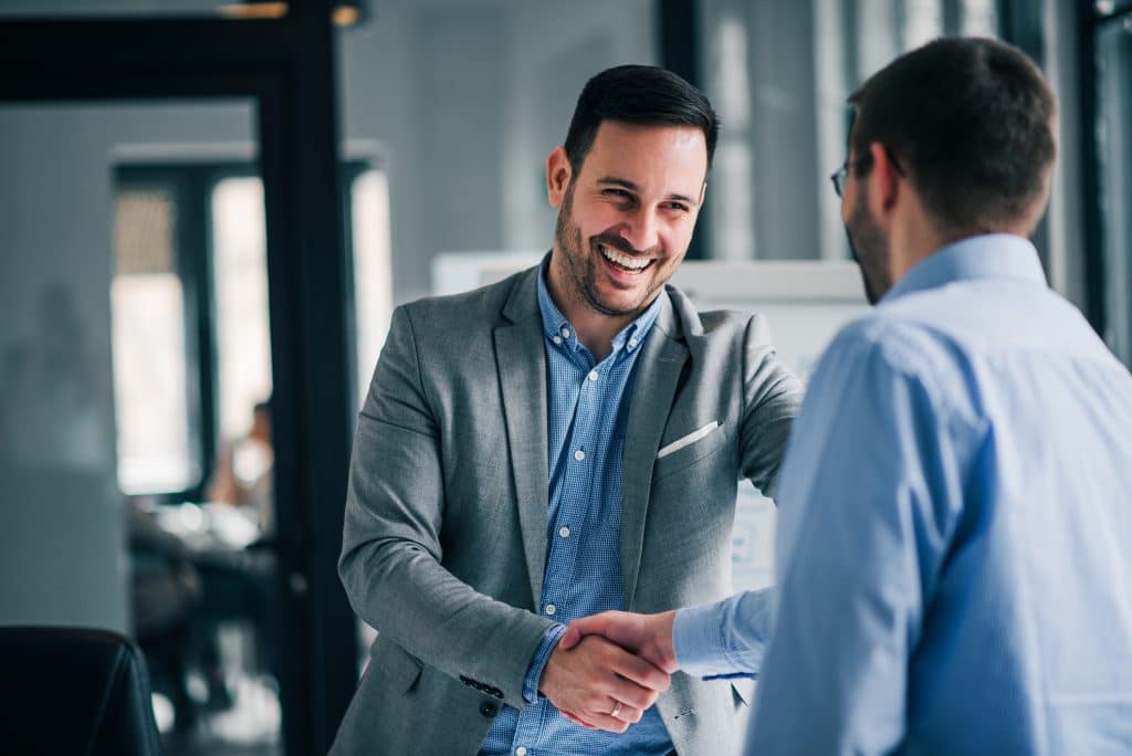 Two office employees who may have had a relocation move shaking hands 