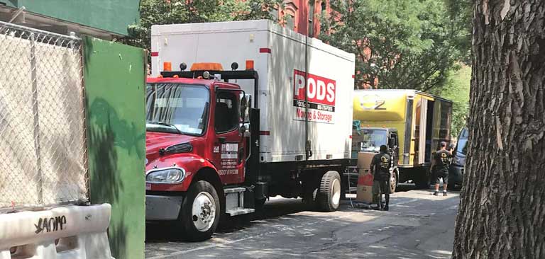 A PODS container on a delivery truck that's parked on a city street