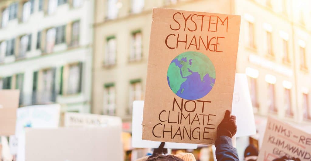 A sign about climate change sign being held at a protest.