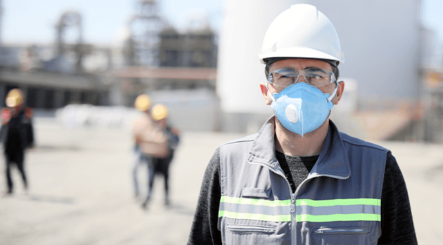 Construction worker wearing a feace mask at a jobsite.
