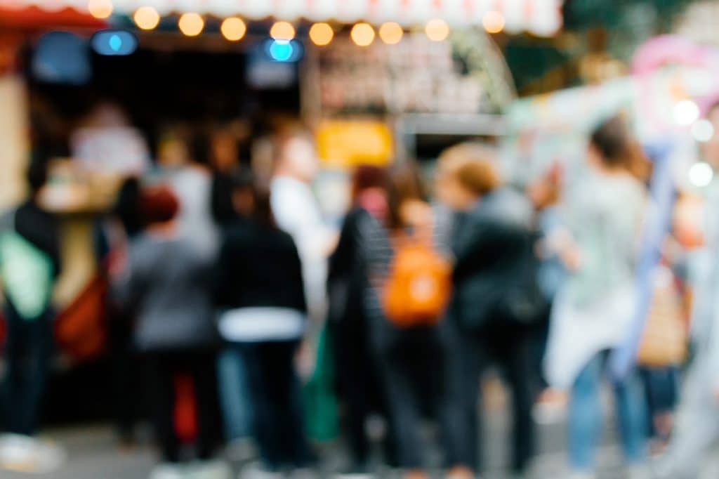 Line of people standing at a shipping container restaurant