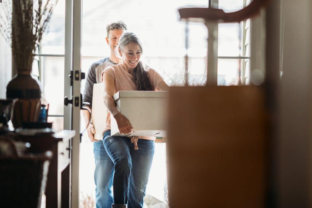 Couple with moving boxes in new home after a relocation