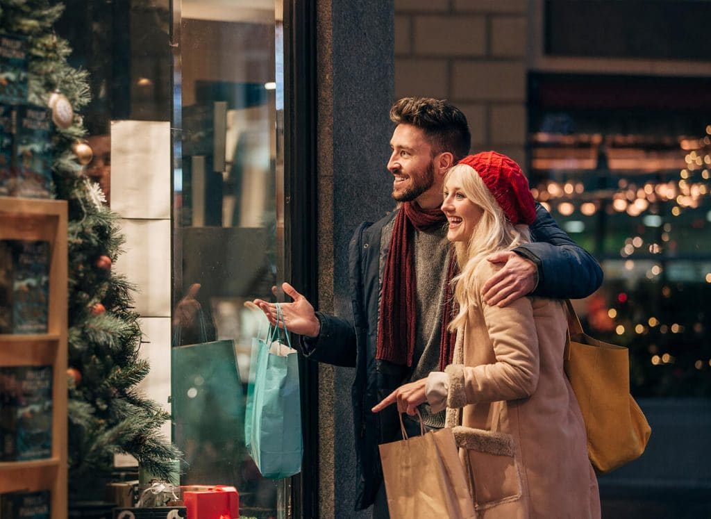 A couple looking at holiday merchandise inside a storefront