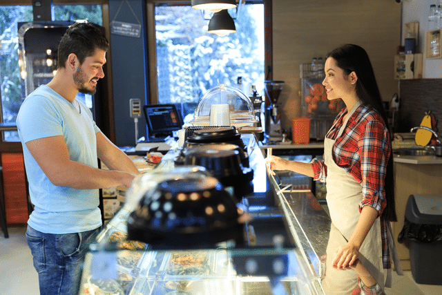 A person ordering food at a fast casual restaurant counter