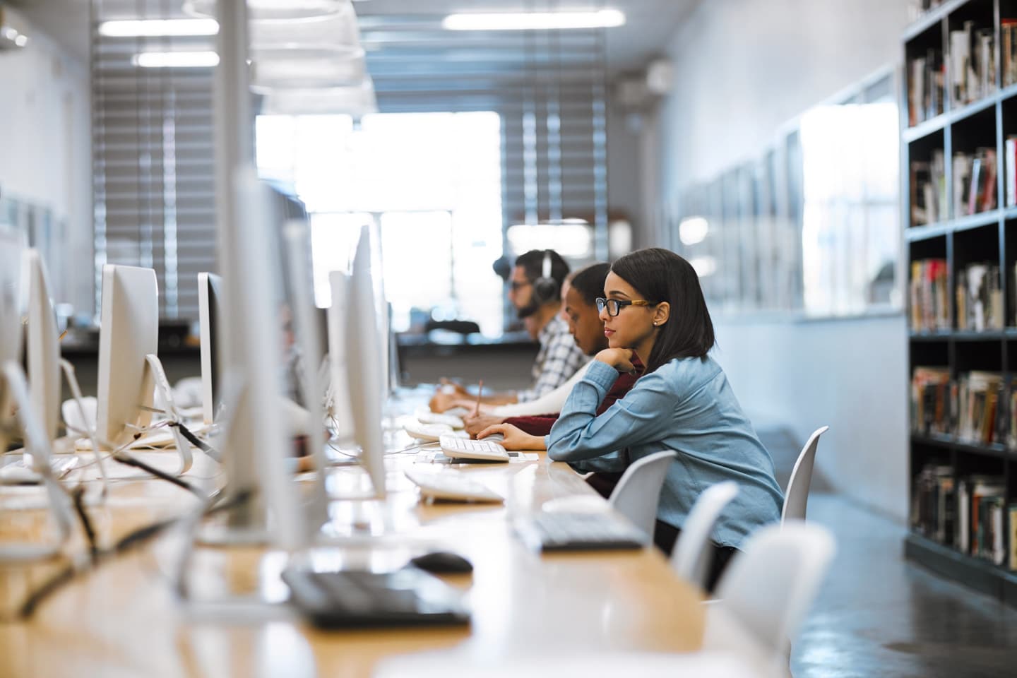 Students studying on computers inside a campus library