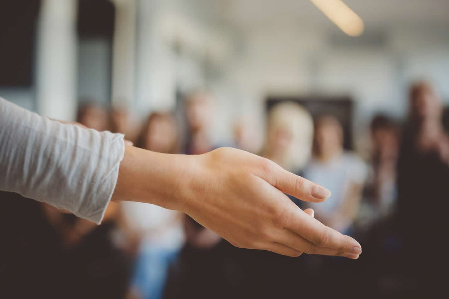 A the hand of a female teacher instructing a group of students