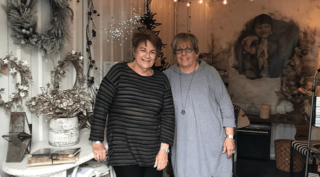 Two women at a pop-up booth inside a PODS container