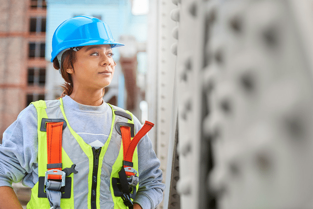 Female crew member wearing construction worker gear