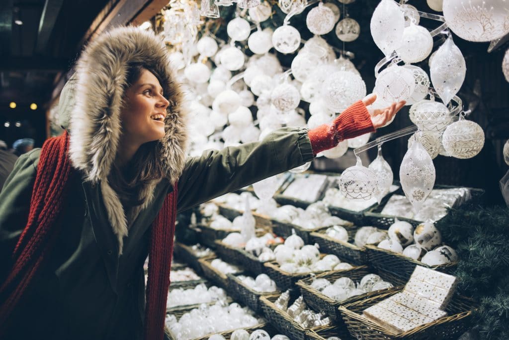 A woman browsing Christmas ornaments at a seasonal pop-up shop.
