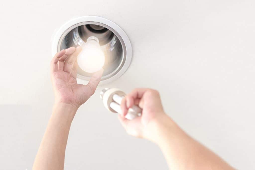 Person changing a lightbulb in a hotel fixture