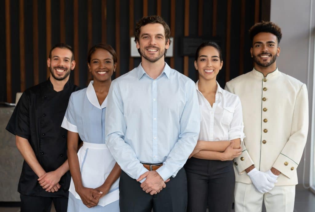 Smiling members of hotel employee staff standing side by side