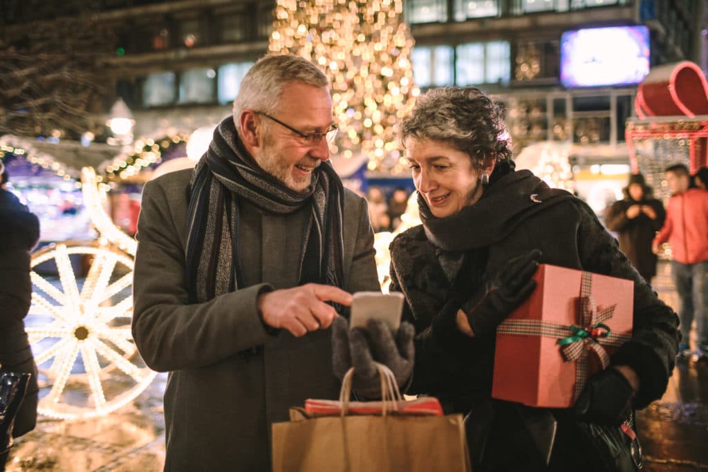 A senior couple going holiday shopping at a Christmas market