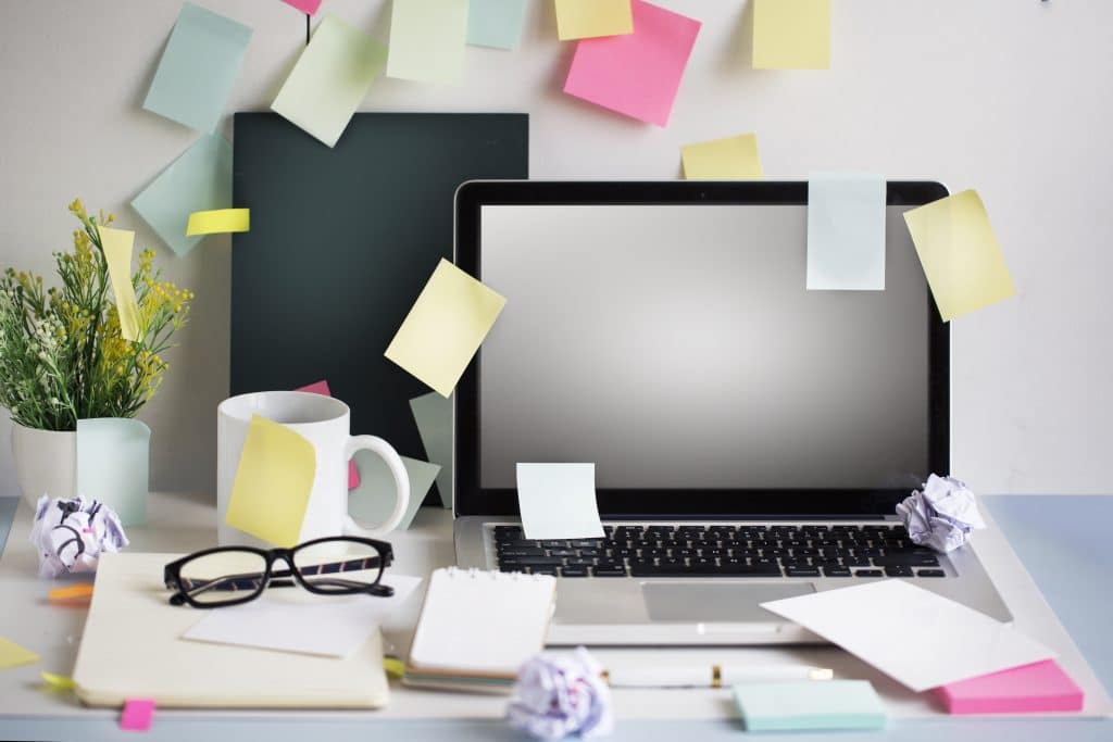 Sticky notes covering a laptop and desk area