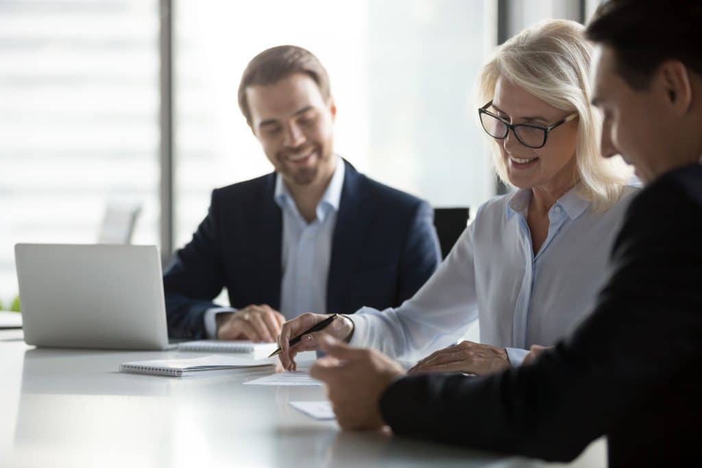 Group of professionals sitting at a table writing a franchise development strategy