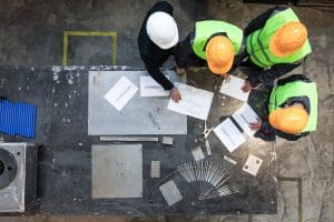 A construction crew reviewing documents and calculating TRIR formula on a jobsite