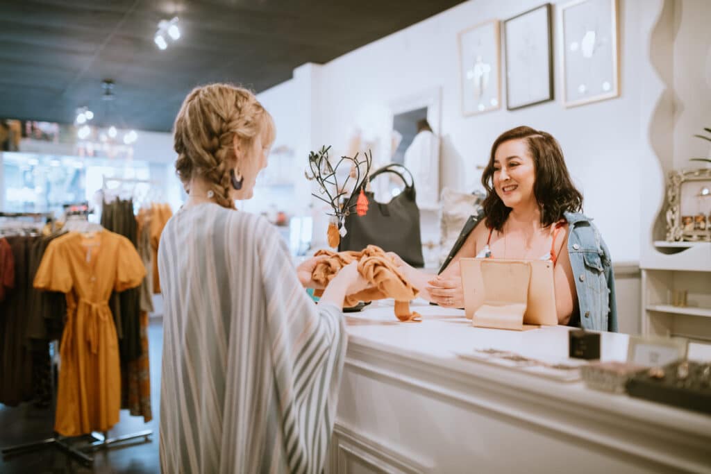 A customer being checked out by a retail employee at a fashion boutique counter