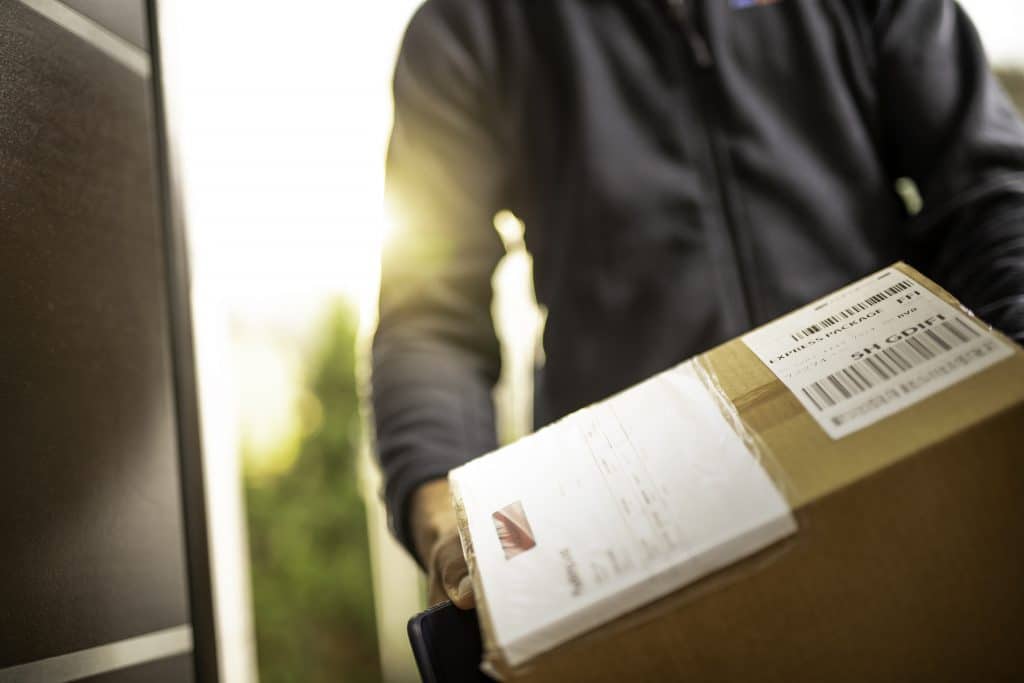 Delivery worker unloading package from inside vehicle