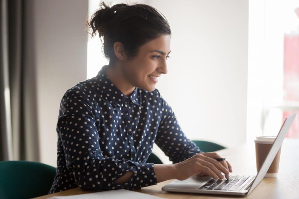 Female non-acute care center employee working at home on a laptop