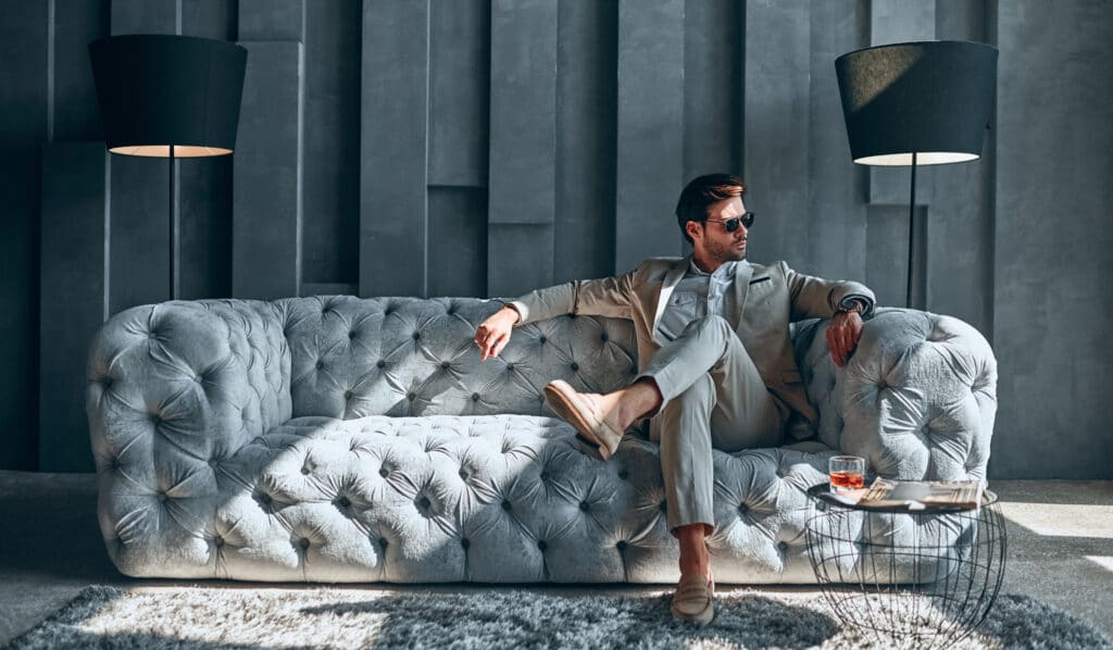 Stylish man sitting on a chic couch inside a 