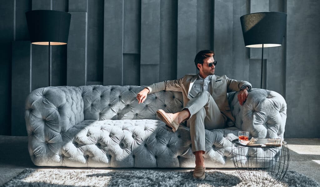 Stylish man sitting on a chic couch inside a