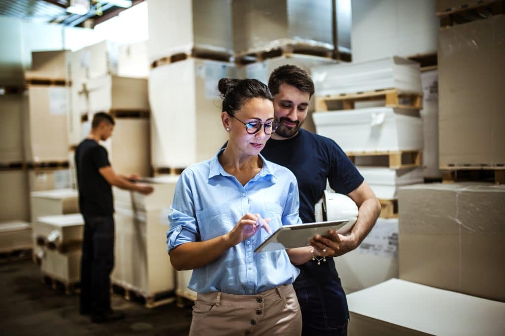 Warehouse employees reviewing inventory for supply chain management