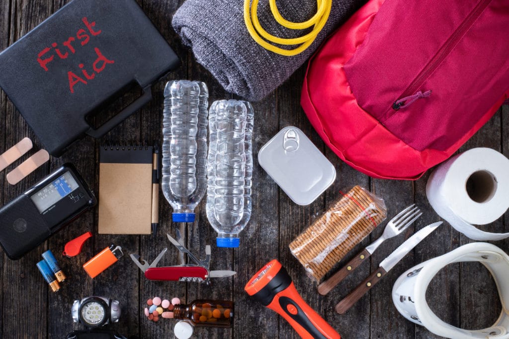 Various natural disaster preparedness supplies spread on a table top