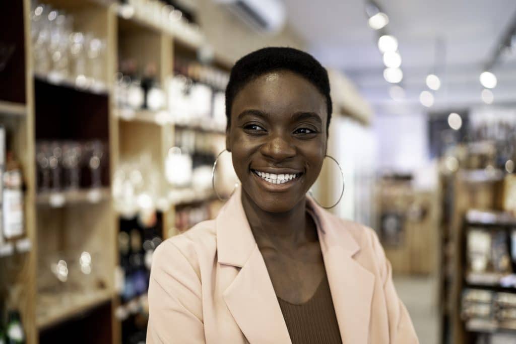 A female restaurant owner smiling while shopping in a food store