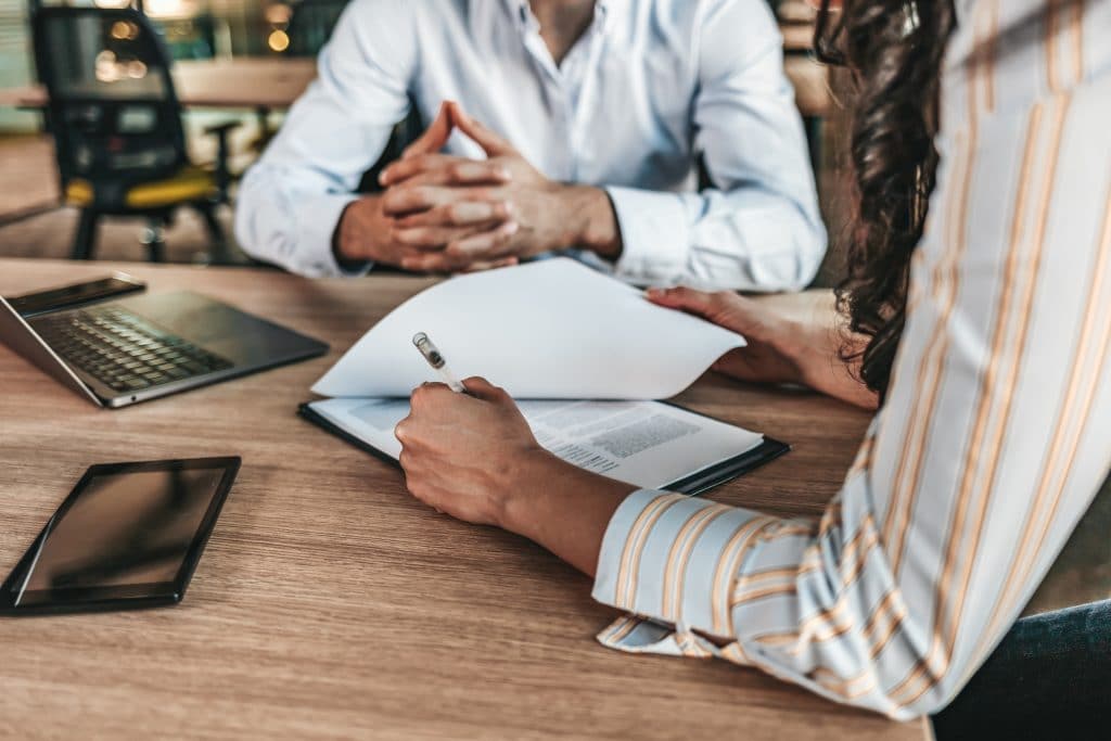 Two government housing professional at a table writing on documents