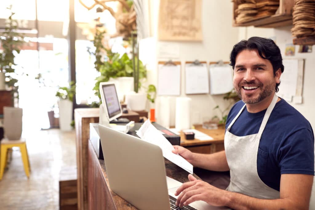 Male employee sitting behind a counter at a gardening retail store