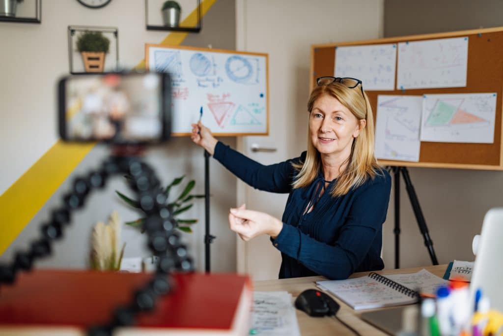 Female teacher recording a lesson on a cellphone 