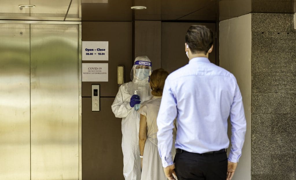 People standing at an event temperature check station