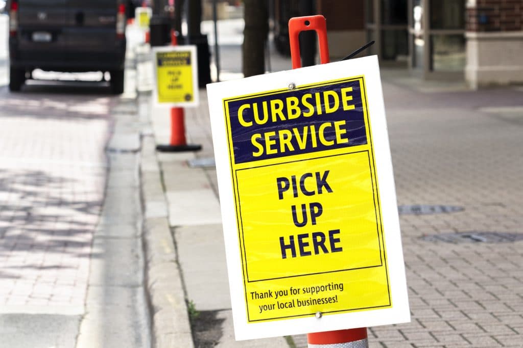 A curbside pickup poster in front of a business