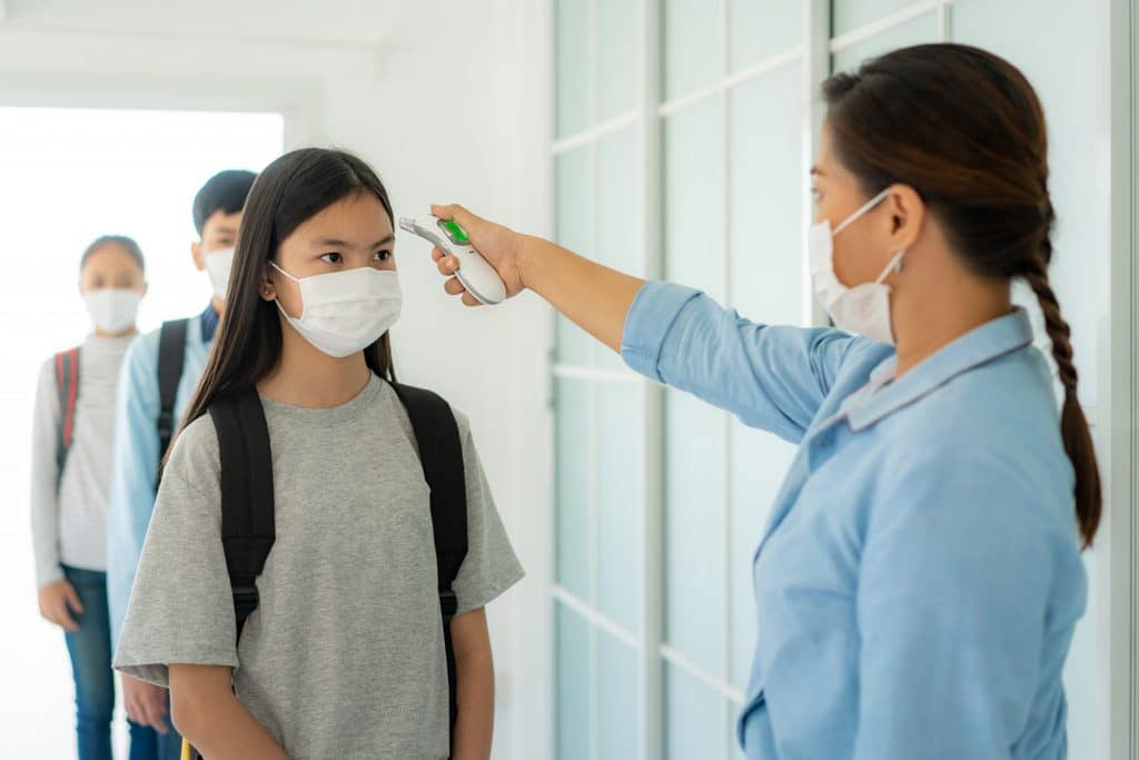 Students standing in line for a temperature check 