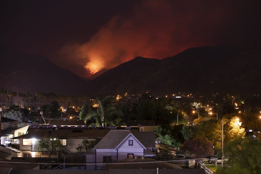 A town at night with wildfires in distance