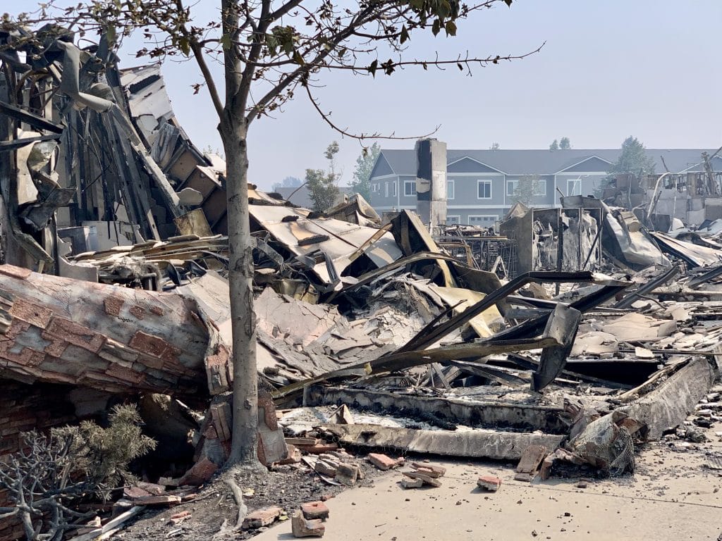 A disaster response site with burnt building in a nieghborhood