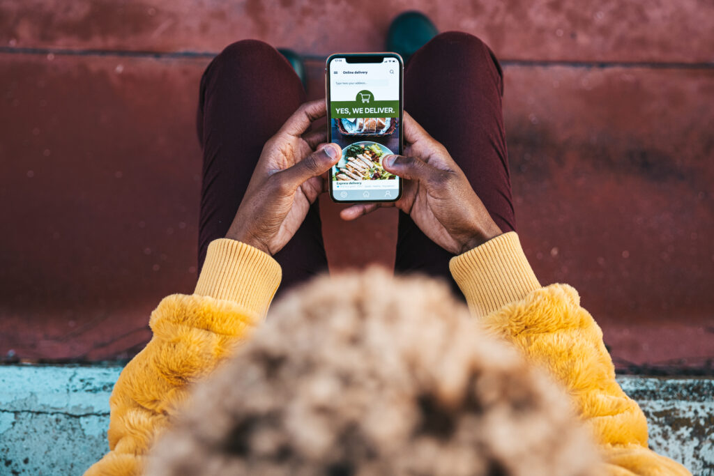 Woman ordering food from a retail grocery store by delivery mobile app