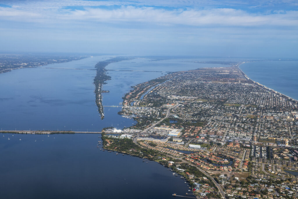 Aerial view of downtown Melbourne, the ocean surrounding it, and the neighboring commercial area