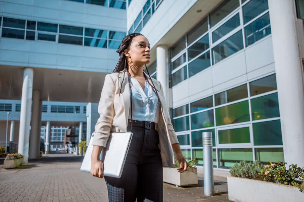 Female healthcare business professional walking outside a hospital