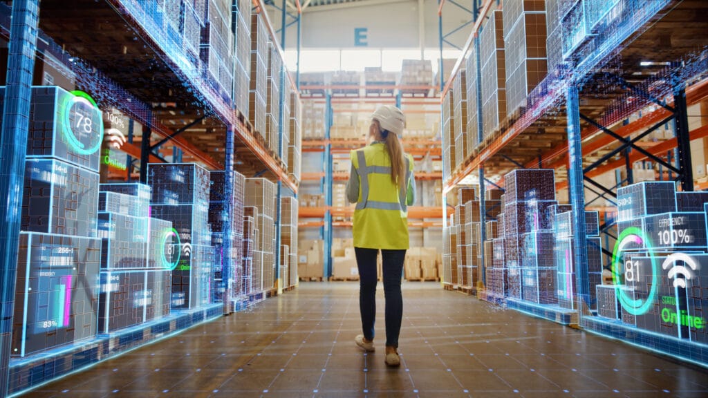 Female warehouse worker walking through warehouse with abstract digitalization on boxes on shelves