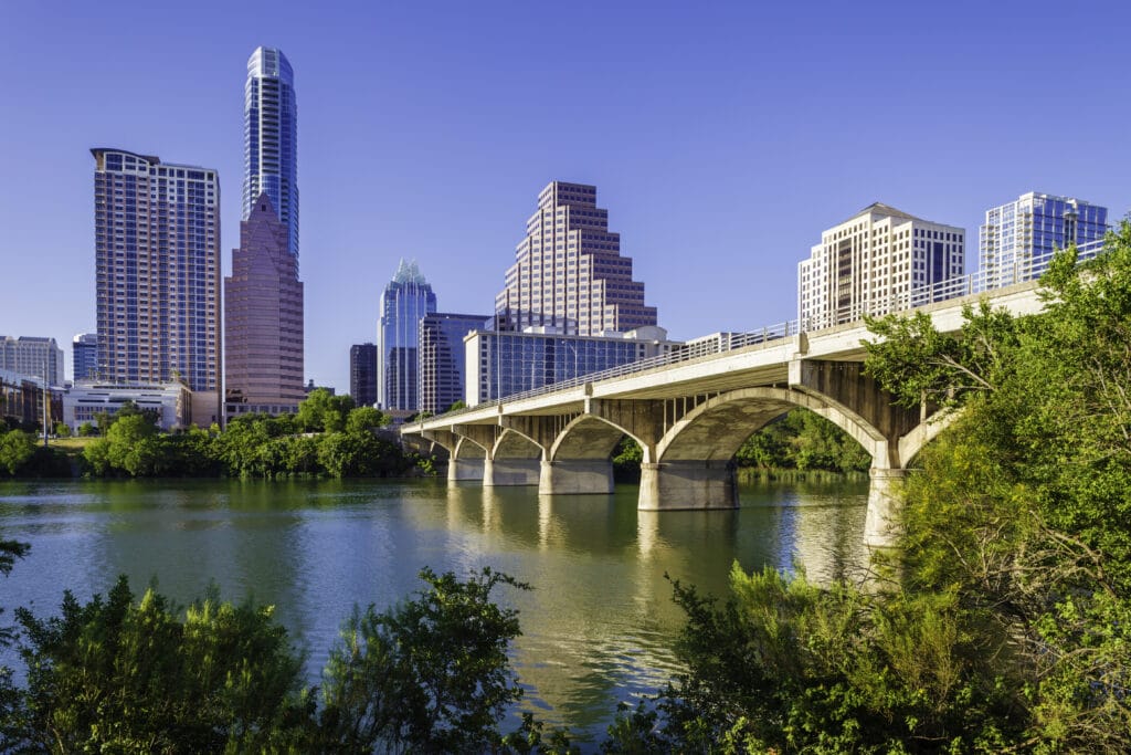 Bridge going over a river in front of the Austin, Texas skyline