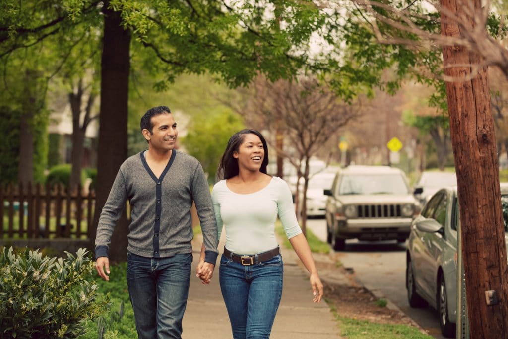 A couple walking on a sidewalk in an Atlanta neighborhood 