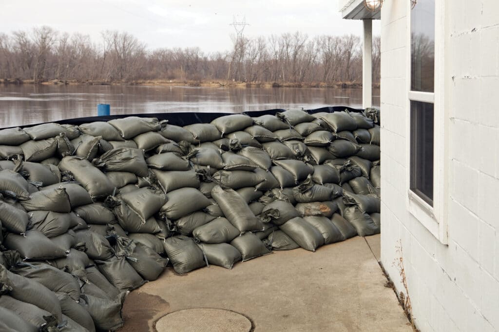 Pile of bags lined against a retaining wall to prepare for extreme weather