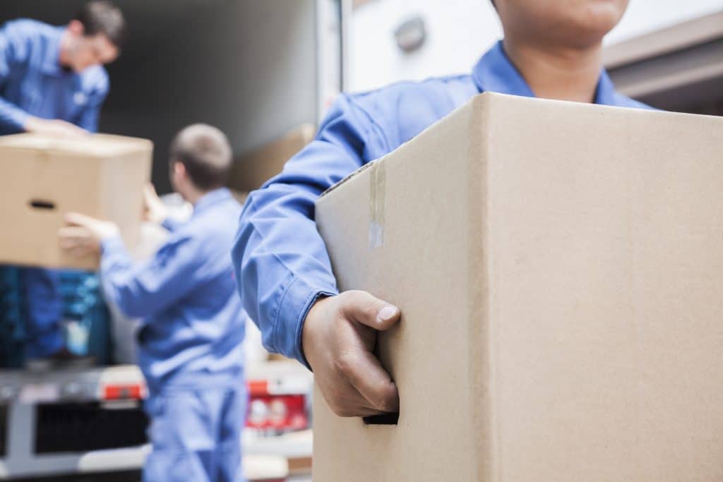 Labor unloading boxes off a moving truck rental