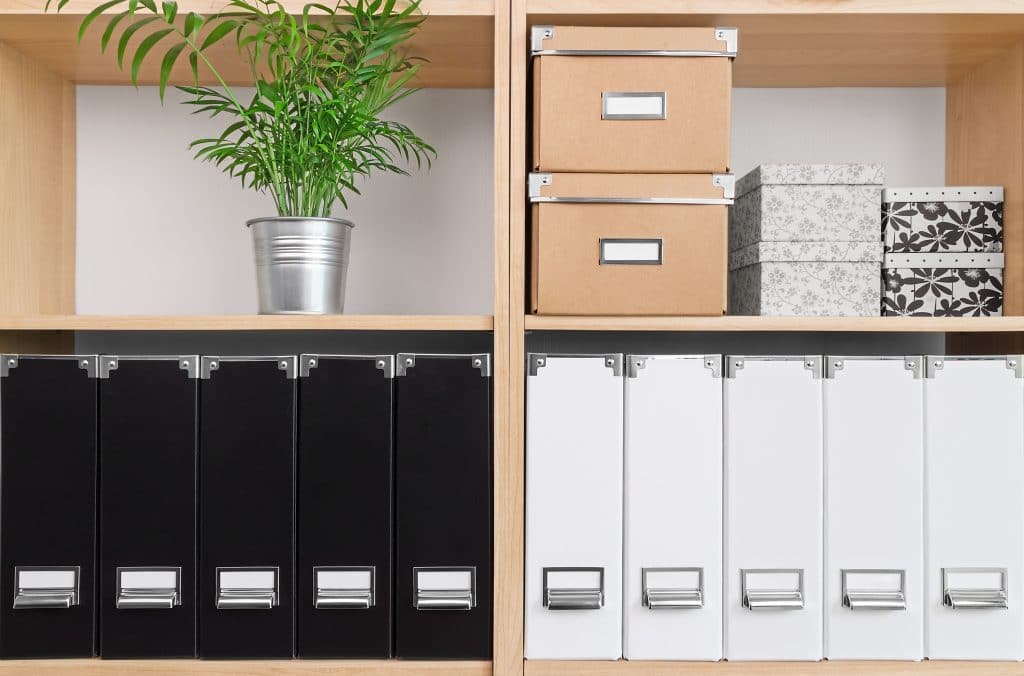 Photo of organized binders and boxes on a shelf at an office
