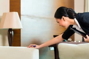 A female hotel employee making notes of furniture inventory for a hotel retrofit project