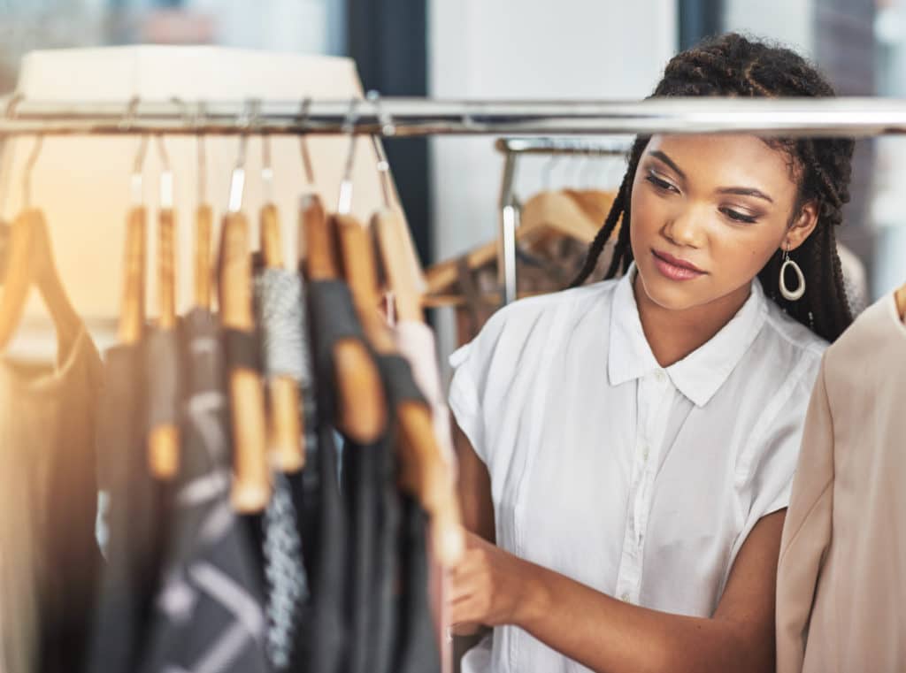 Female shopper browsing garments inside a clothing store during the holiday retail season