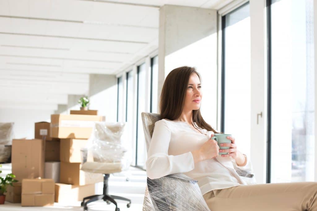 Female employee gazing out the window of a brand new office