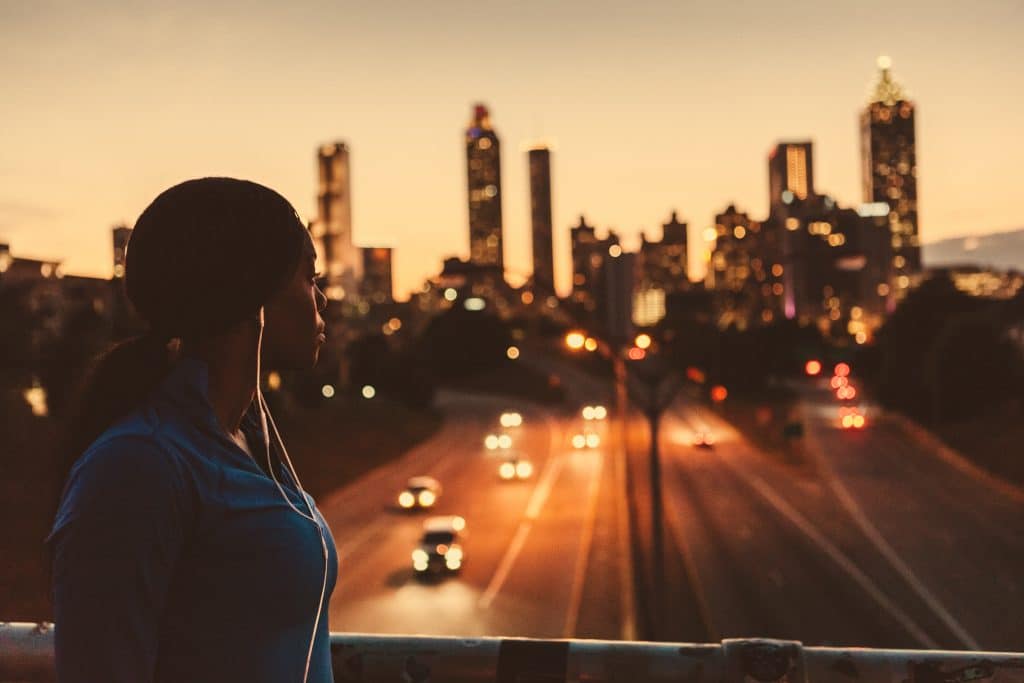 Woman jogger looking over the Atlanta skyline at sunset